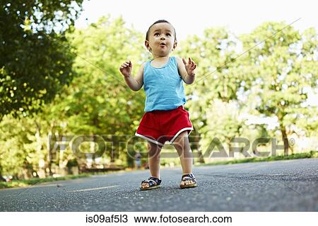 Stock Image - Baby boy standing on park path. Fotosearch