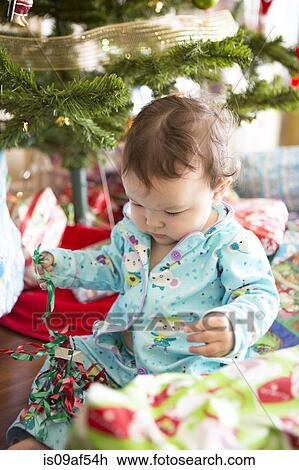 Baby girl opening christmas presents on her first Christmas View Large Photo Image Stock Image - Baby girl opening christmas presents on her first Christmas. Fotosearch