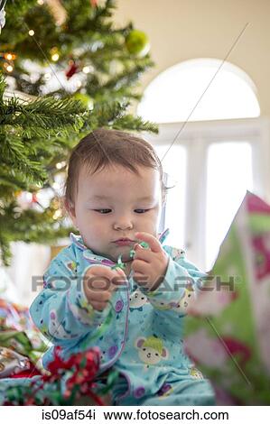 Baby girl opening christmas presents on her first Christmas View Large Photo Image Stock Image - Baby girl opening christmas presents on her first Christmas. Fotosearch
