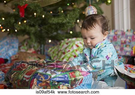 Baby girl opening presents on her first Christmas View Large Photo Image Stock Image - Baby girl opening presents on her first Christmas. Fotosearch