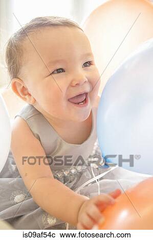 Baby girl wearing party dress with balloon View Large Photo Image Stock Image - Baby girl wearing party dress with balloon. Fotosearch