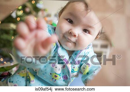 Baby girl wearing pyjamas reaching towards camera View Large Photo Image Stock Image - Baby girl wearing pyjamas reaching towards camera. Fotosearch