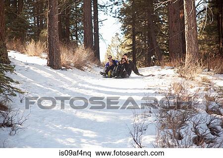Boy and young adults sledging in snowy forest View Large Photo Image Stock Photography - Boy and young adults sledging in snowy forest. Fotosearch