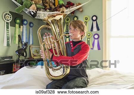 Boy playing tuba in bedroom View Large Photo Image Stock Photo - Boy playing tuba in bedroom. Fotosearch