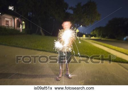 Stock Photo - Boy playing with sparklers. Fotosearch