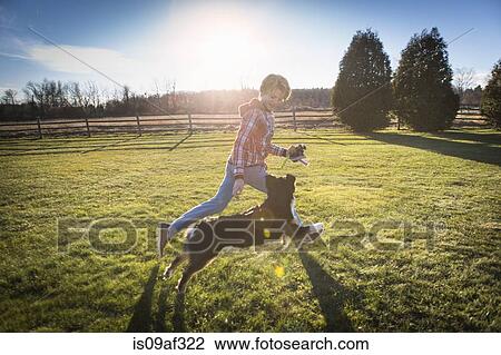 Stock Image - Boy running with dog. Fotosearch