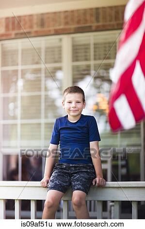 Stock Photograph - Boy sitting on railing. Fotosearch