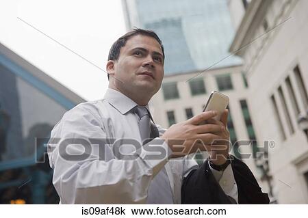 Businessman in city surrounded by skyscrapers View Large Photo Image Stock Image - Businessman in city surrounded by skyscrapers. Fotosearch