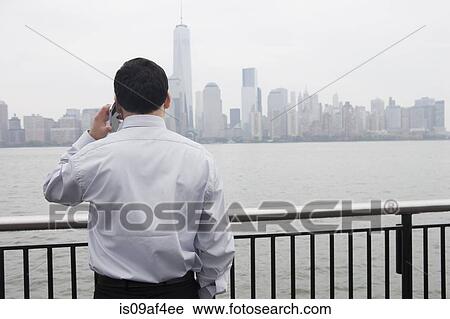 Stock Image - Businessman using cellular phone, Hoboken, New Jersey, USA. Fotosearch
