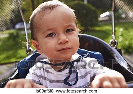 Close up of baby boy on park swing View Large Photo Image Stock Photo - Close up of baby boy on park swing. Fotosearch