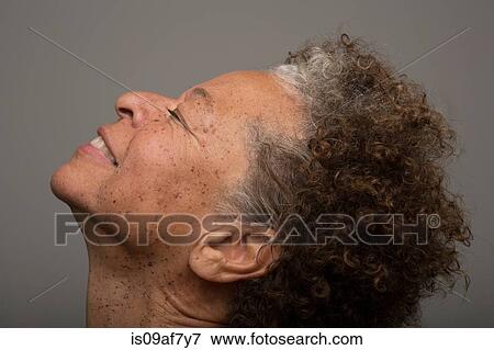 Stock Photo - Close up studio portrait of senior woman with head back and eyes closed. Fotosearch