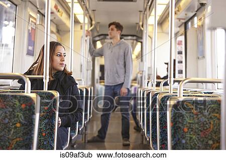 Stock Image - Commuters on empty subway train. Fotosearch