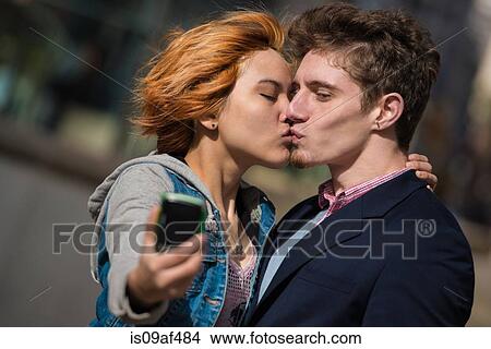 Couple taking selfies in the city View Large Photo Image Picture - Couple taking selfies in the city. Fotosearch