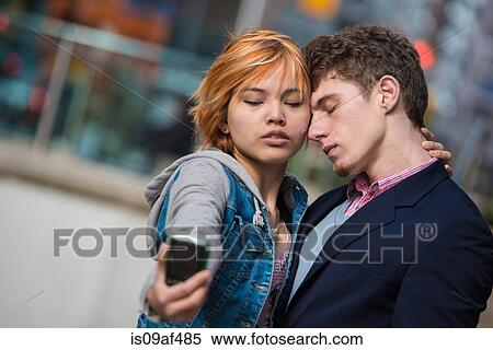 Couple taking selfies in the city View Large Photo Image Stock Photography - Couple taking selfies in the city. Fotosearch