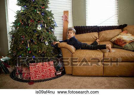 Excited male toddler looking at decorations on xmas tree View Large Photo Image Stock Photograph - Excited male toddler looking at decorations on xmas tree. Fotosearch