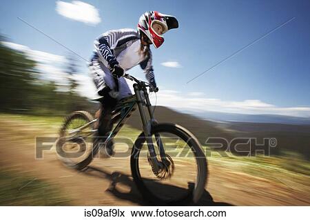 Female mountain biker speeding down dirt track View Large Photo Image Stock Photo - Female mountain biker speeding down dirt track. Fotosearch