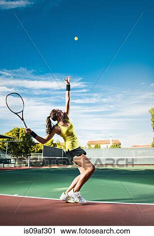 Stock Image - Female tennis player hitting ball. Fotosearch