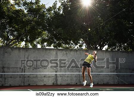 Stock Photo - Female tennis player hitting ball. Fotosearch
