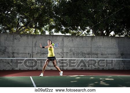 Stock Photo - Female tennis player hitting ball. Fotosearch