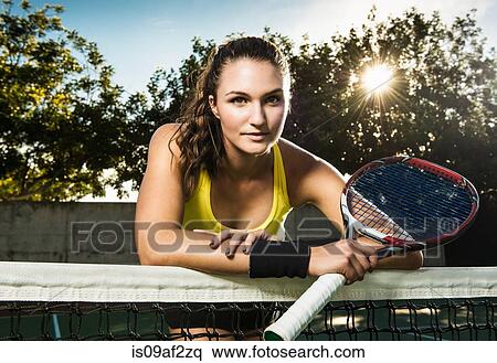 Female tennis player holding racket leaning on net View Large Photo Image Stock Photography - Female tennis player holding racket leaning on net. Fotosearch