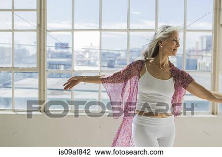 Graceful senior woman dancing in sunlit apartment View Large Photo Image Stock Image - Graceful senior woman dancing in sunlit apartment. Fotosearch