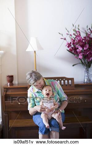 Stock Photo - Grandmother and granddaughter sitting on bench. Fotosearch