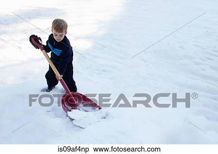 Stock Photography - Male toddler digging snow with large shovel. Fotosearch