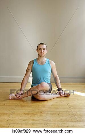 Stock Photo - Man in Cowface yoga pose. Fotosearch