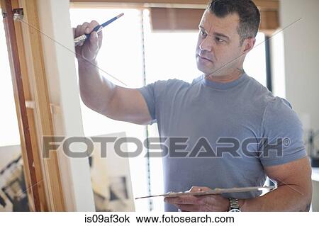 Mature male artist working on canvas in studio View Large Photo Image Stock Image - Mature male artist working on canvas in studio. Fotosearch