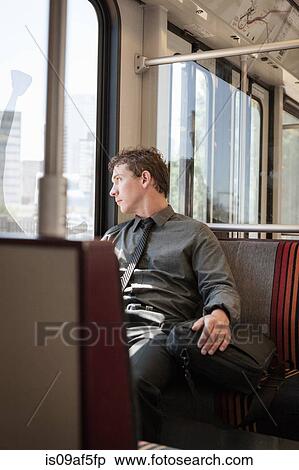 Mid adult businessman looking out of train carriage window View Large Photo Image Stock Photography - Mid adult businessman looking out of train carriage window. Fotosearch