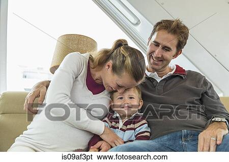 Mid adult couple and toddler son sitting on couch View Large Photo Image Stock Photograph - Mid adult couple and toddler son sitting on couch. Fotosearch