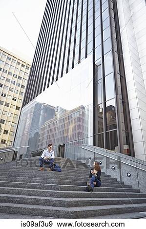 Mid adult man chatting up young woman whilst sitting on steps View Large Photo Image Stock Photo - Mid adult man chatting up young woman whilst sitting on steps. Fotosearch