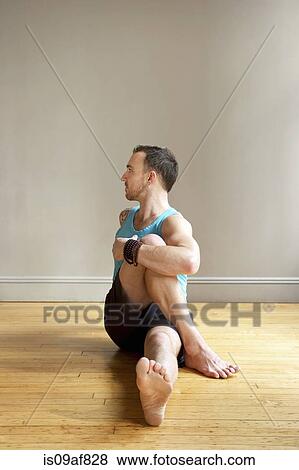 Stock Photo - Mid adult man twisting back. Fotosearch