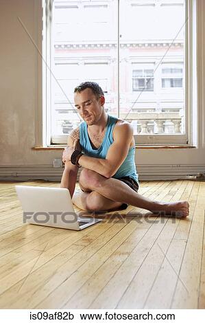 Mid adult man using laptop whilst in Cowface yoga pose View Large Photo Image Stock Image - Mid adult man using laptop whilst in Cowface yoga pose. Fotosearch