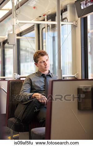 Stock Photograph - Mid adult office worker looking bored on train journey. Fotosearch
