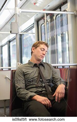 Mid adult office worker snoozing on train journey View Large Photo Image Stock Photograph - Mid adult office worker snoozing on train journey. Fotosearch