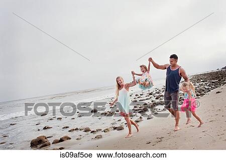 Parents and two young girls walking on beach View Large Photo Image Stock Image - Parents and two young girls walking on beach. Fotosearch