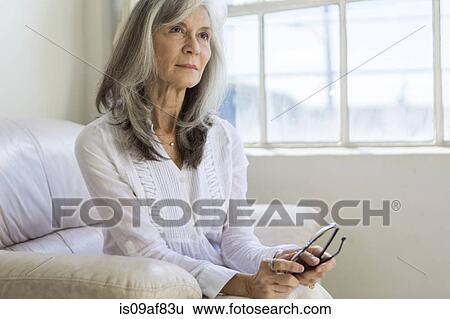 Portrait of attractive senior woman sitting in apartment View Large Photo Image Stock Photograph - Portrait of attractive senior woman sitting in apartment. Fotosearch