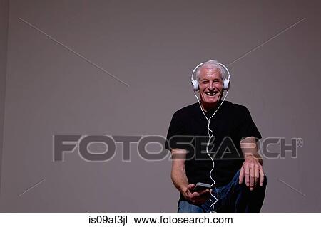 Portrait of senior man listening to MP3 player on headphones View Large Photo Image Stock Image - Portrait of senior man listening to MP3 player on headphones. Fotosearch