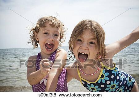 Portrait of two sisters pulling faces on beach at Falmouth, Massachusetts, USA View Large Photo Image Stock Photo - Portrait of two sisters pulling faces on beach at Falmouth, Massachusetts, USA. Fotosearch