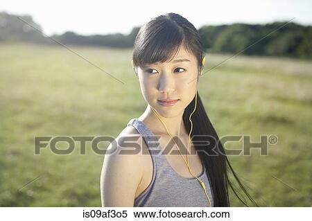 Stock Photography - Portrait of young female runner wearing earphones. Fotosearch