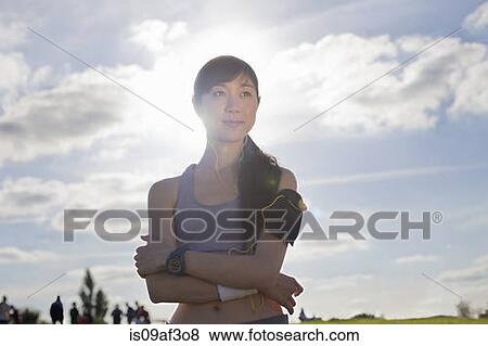 Stock Photo - Portrait of young female runner with arms folded. Fotosearch
