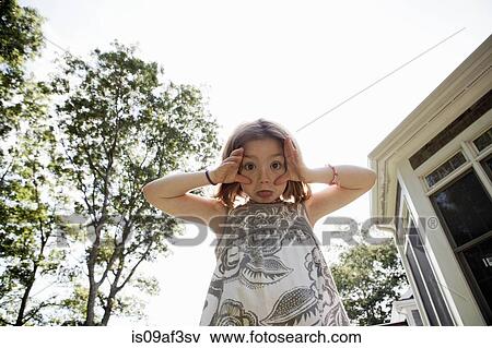 Stock Photo - Portrait of young girl pulling a face. Fotosearch