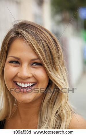 Stock Image - Portrait of young woman with blonde hair smiling. Fotosearch