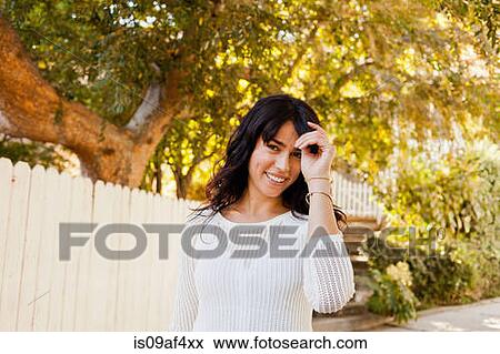 Stock Photo - Portrait of young woman with hand in hair. Fotosearch