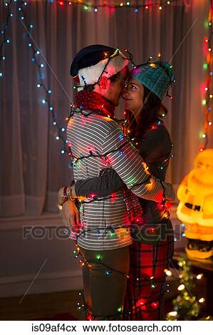 Romantic young couple wrapped in fairy lights at christmas View Large Photo Image Stock Photo - Romantic young couple wrapped in fairy lights at christmas. Fotosearch