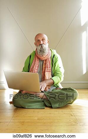 Senior man using laptop in lotus position View Large Photo Image Stock Photograph - Senior man using laptop in lotus position. Fotosearch