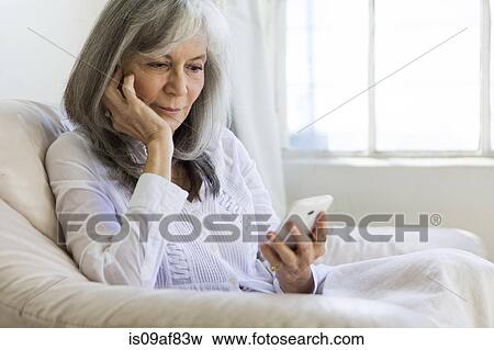 Stock Photo - Senior woman looking at smartphone. Fotosearch