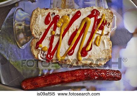 Still life of bread bun, mustard, tomato sauce and a hot dog sausage View Large Photo Image Stock Photography - Still life of bread bun, mustard, tomato sauce and a hot dog sausage. Fotosearch