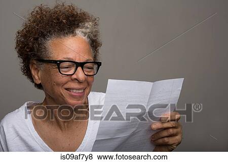 Studio portrait of happy senior woman reading a letter View Large Photo Image Stock Photo - Studio portrait of happy senior woman reading a letter. Fotosearch